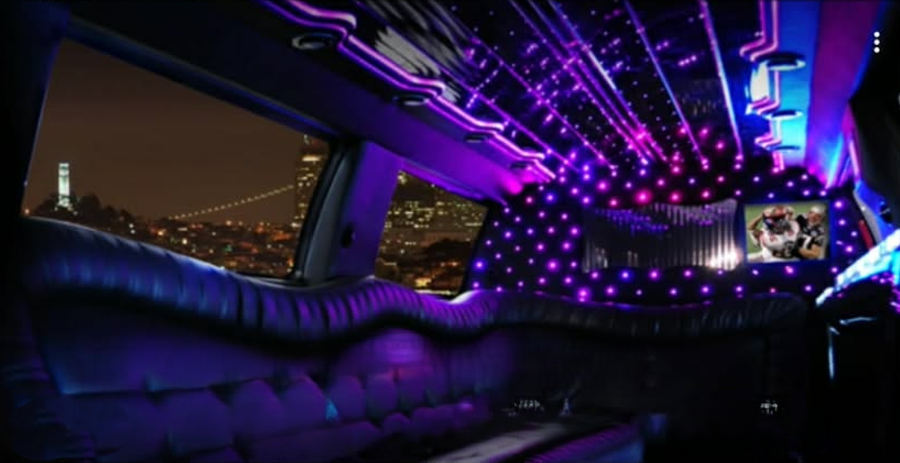 Stretch limousine interior with purple LED lighting and a San Francisco skyline view